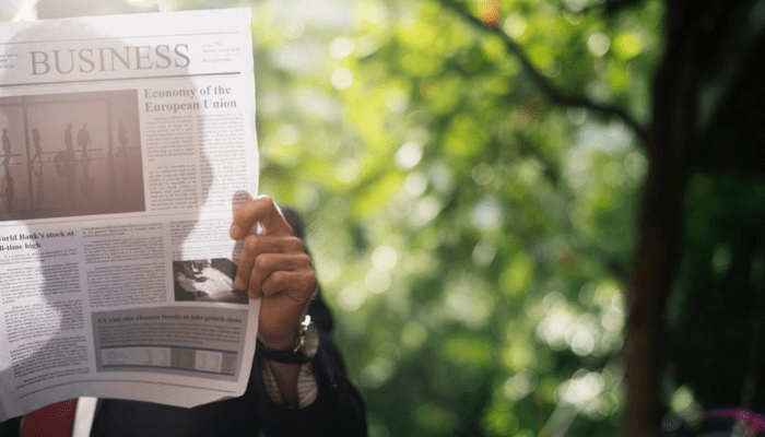 A person reading a news article on a smartphone, representing the need to pause before trusting a dramatic headline.